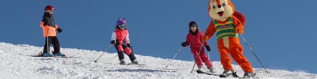 Paco la mascotte en ski avec des enfants